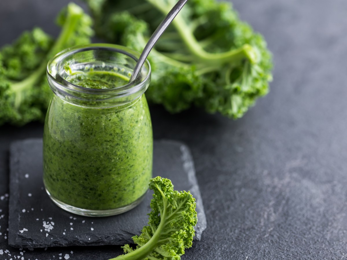 Grünkohl Pesto in einem Glas auf grauem Untergrund