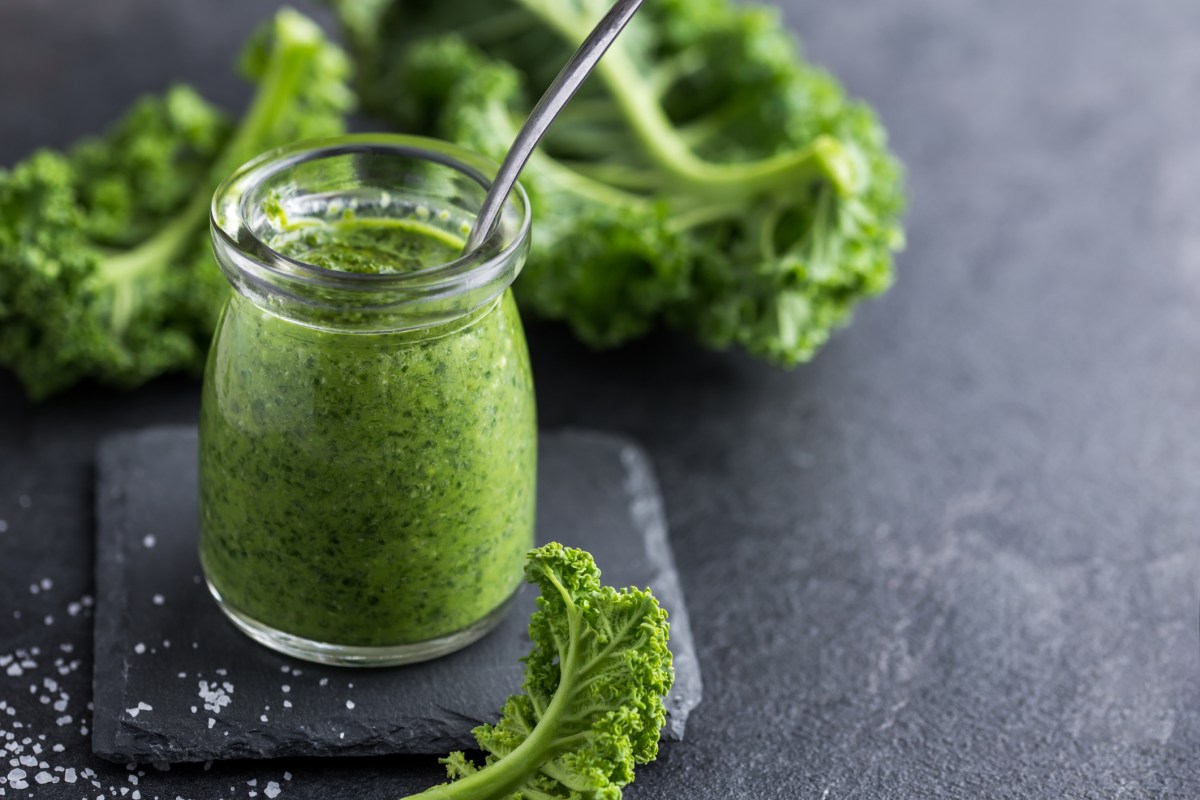 Grünkohl Pesto in einem Glas auf grauem Untergrund