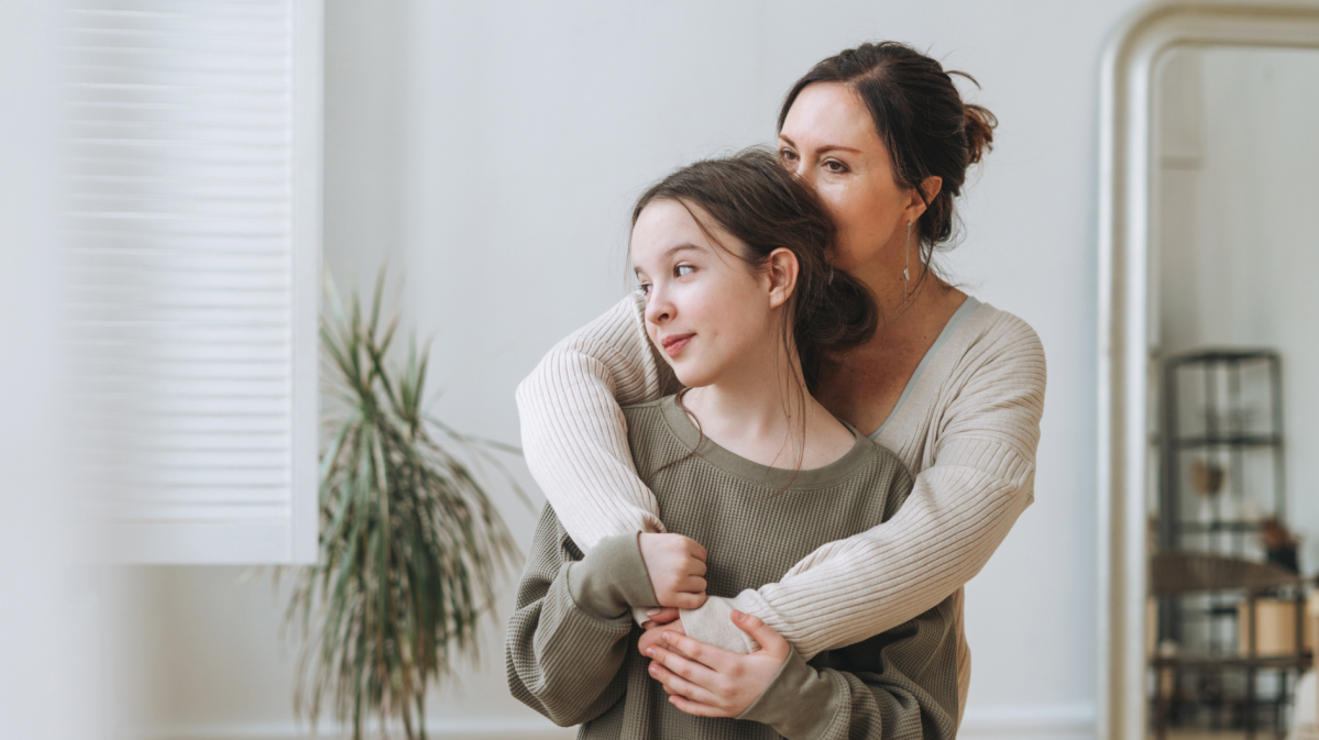 Mutter und Tochter im Teenageralter umarmen sich