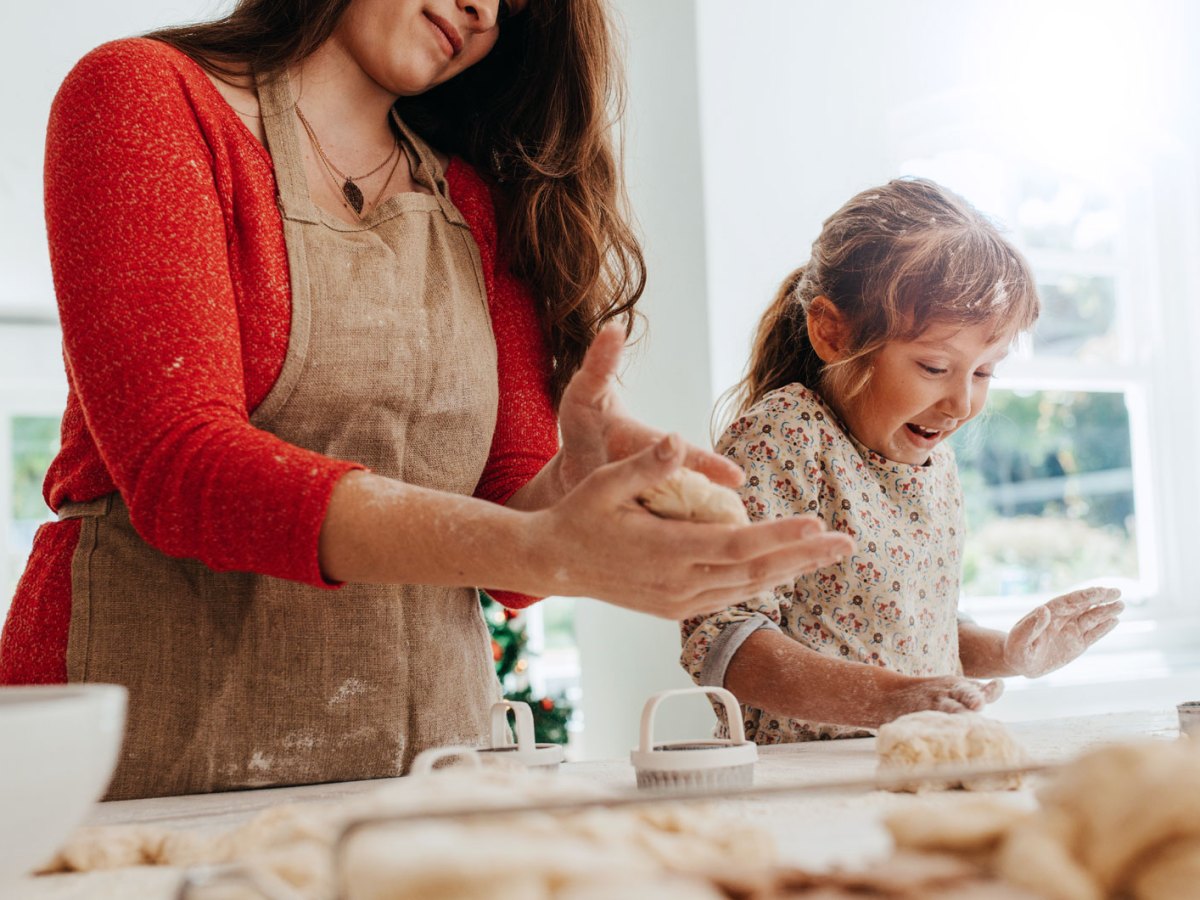 Mtter und Tochter haben sichtlich Spaß beim Backen von Weihnachtsplätzchen.