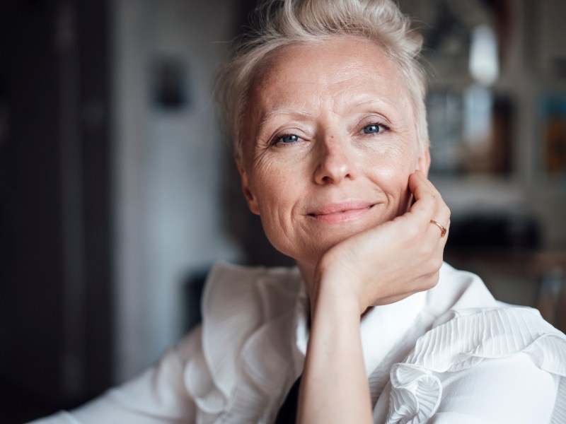 Mittelalöte Frau mit hellem Haar schaut selbstbewusst in die Kamera, Symbolbild für Sternzeichen Widder