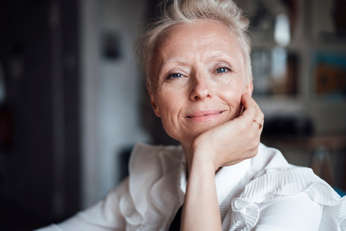 Mittelalöte Frau mit hellem Haar schaut selbstbewusst in die Kamera, Symbolbild für Sternzeichen Widder