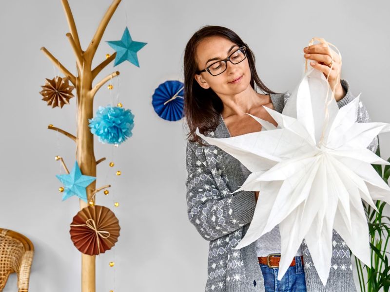 Eine Frau hält einen selbstgebastelten Weihnachtsstern in der Hand