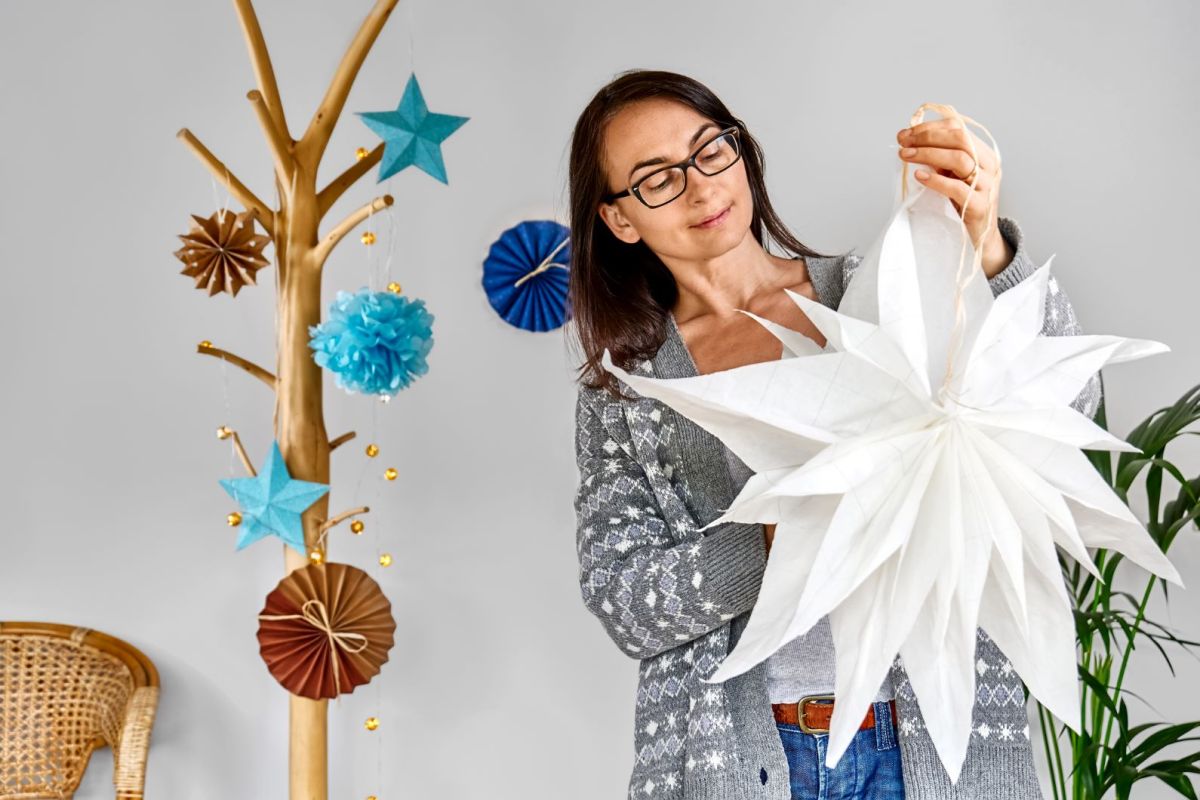 Eine Frau hält einen selbstgebastelten Weihnachtsstern in der Hand