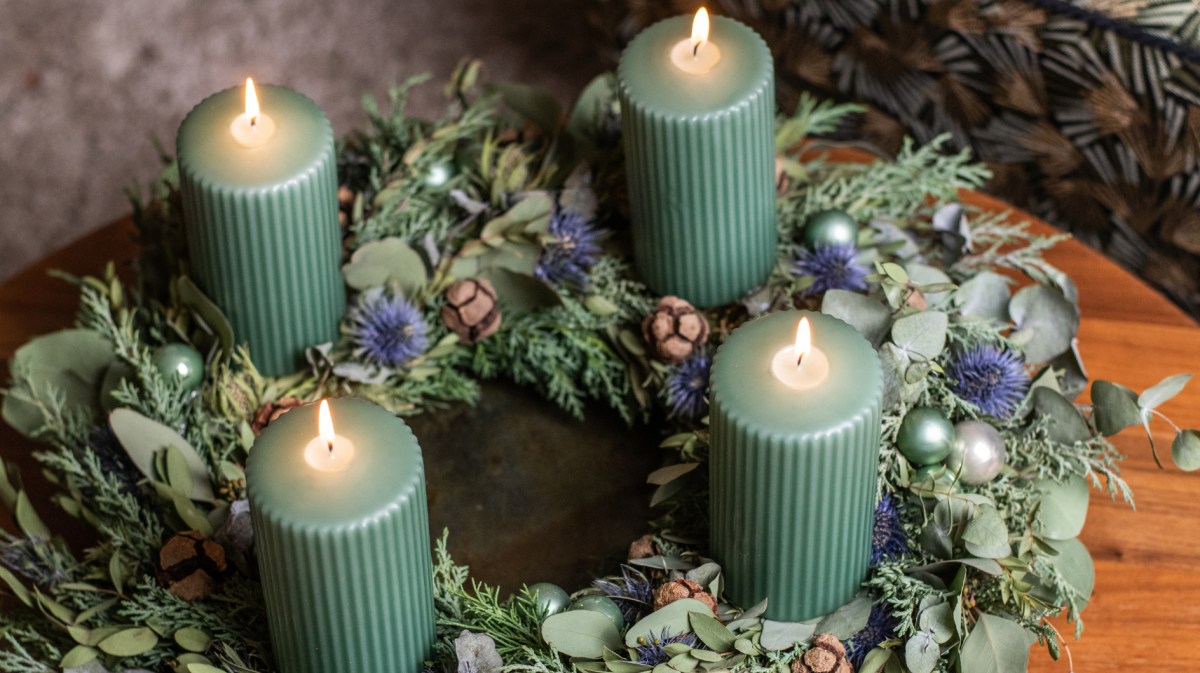 Adventskranz mit Eukalyptus und grünen Kerzen.