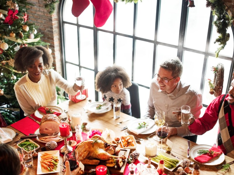 Große Familie sitzt an Weihnachten zum Essen an Tisch zusammen.