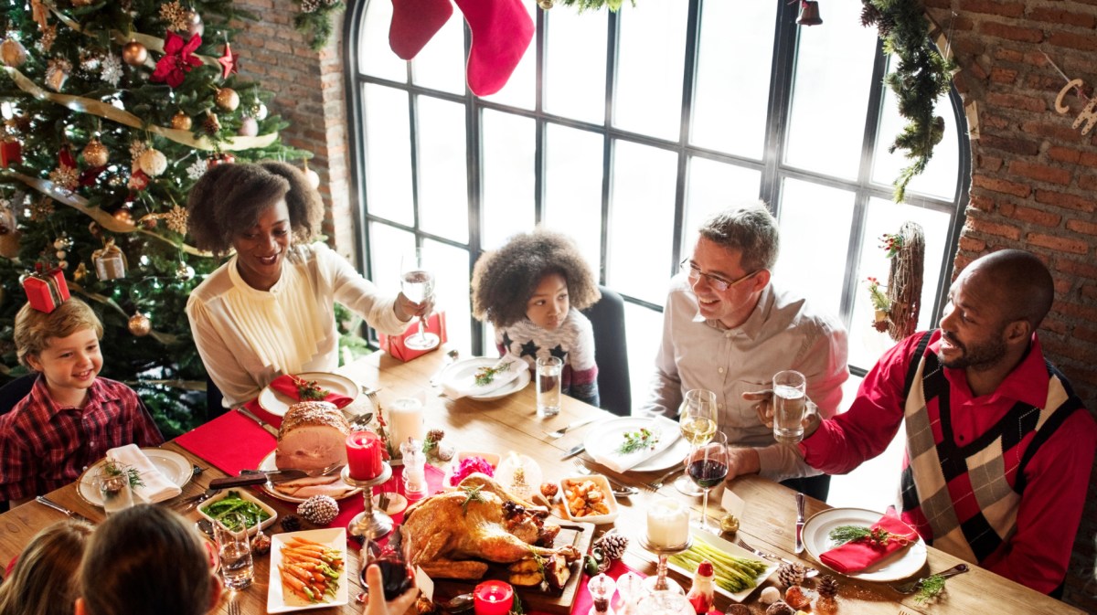 Große Familie sitzt an Weihnachten zum Essen an Tisch zusammen.