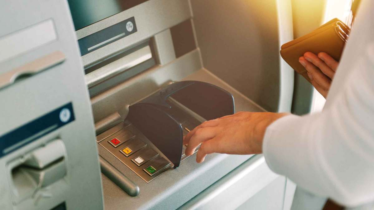 Frau hebt Geld am Bankautomaten ab.