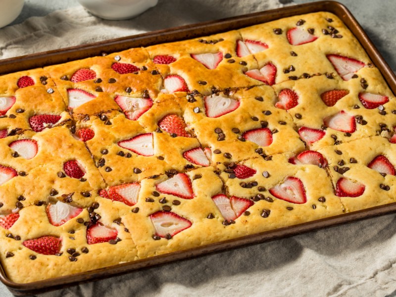 Riesiger Backblech-Pfannkuchen mit Erdbeeren und Schokotropfen.