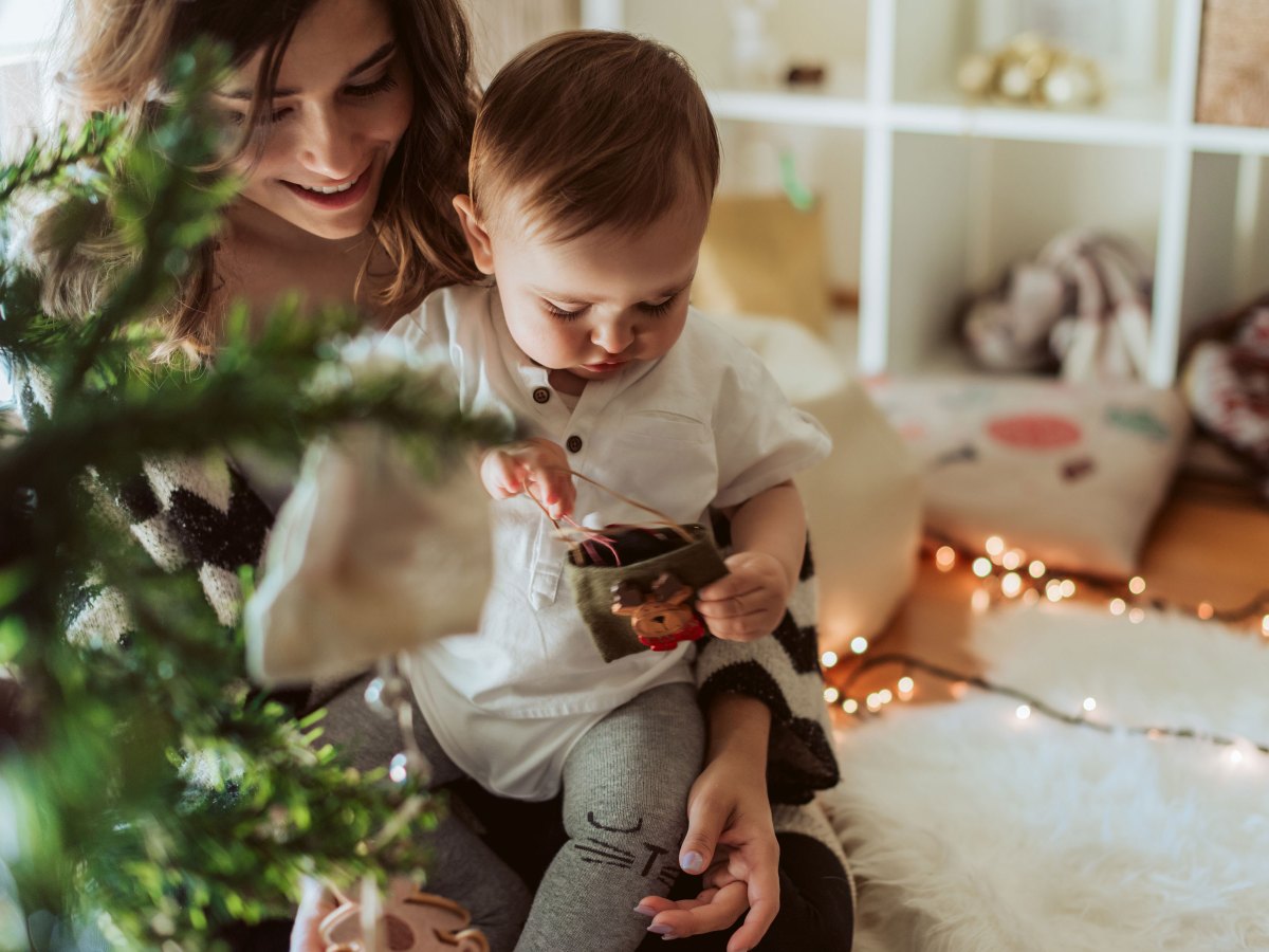 Mutter mit Baby unterm Weihnachtsbaum