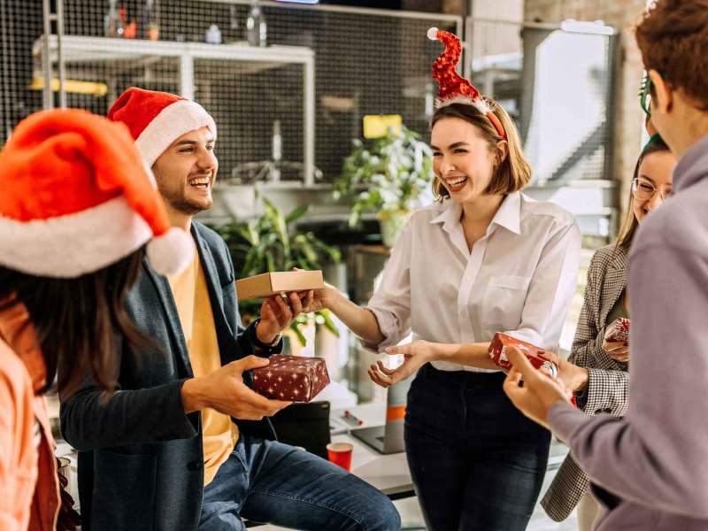 Gruppe überreicht sich beim Schrottwichteln Geschenke.