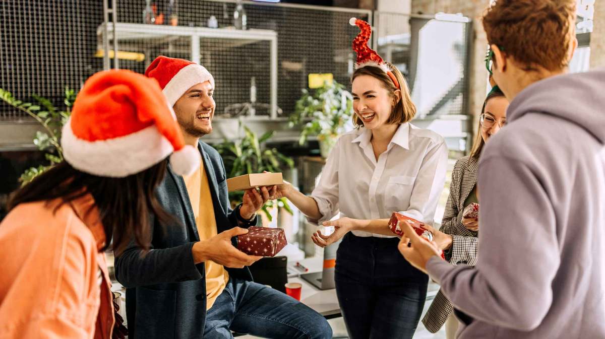 Gruppe überreicht sich beim Schrottwichteln Geschenke.