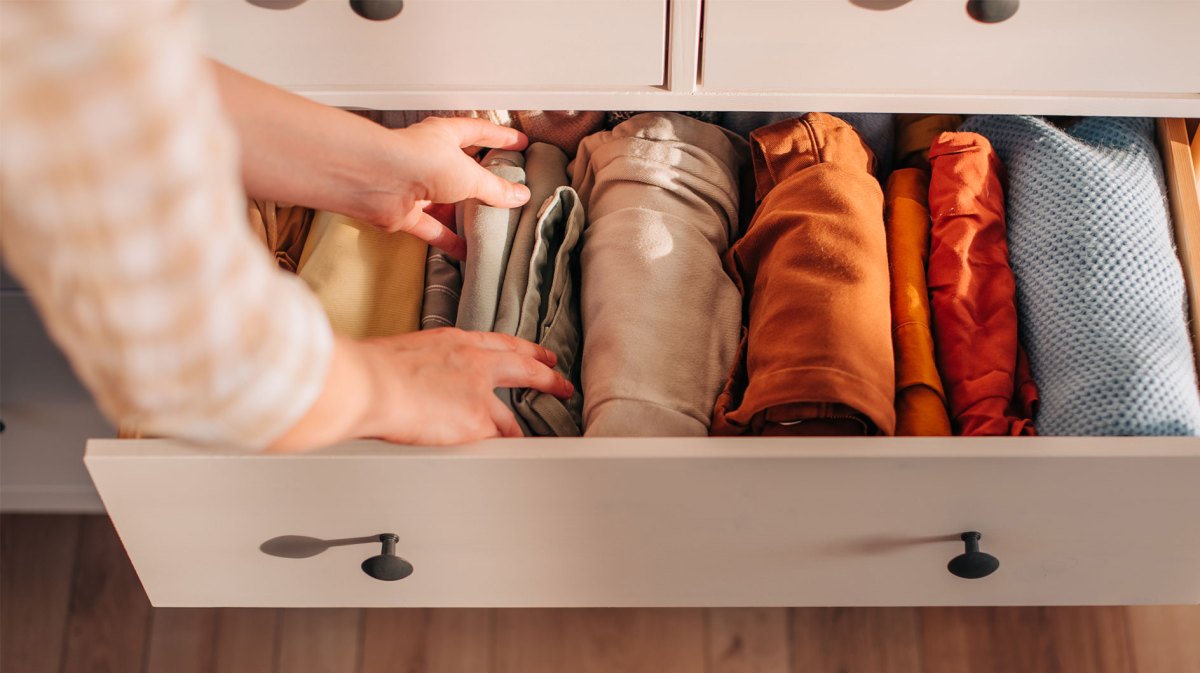 Frau, die Hosen in eine Schublade sortiert.