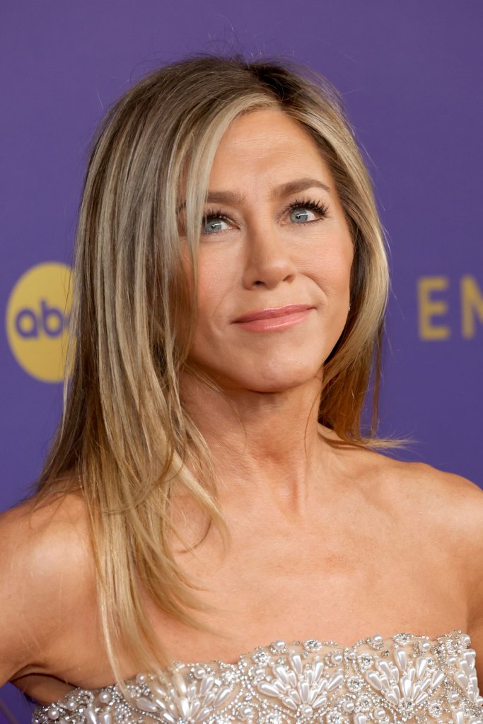 Jennifer Aniston mit gestuften Haaren und Seitenscheitel.