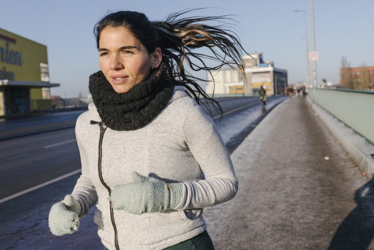 Sportliche Frau joggt bei Kälte