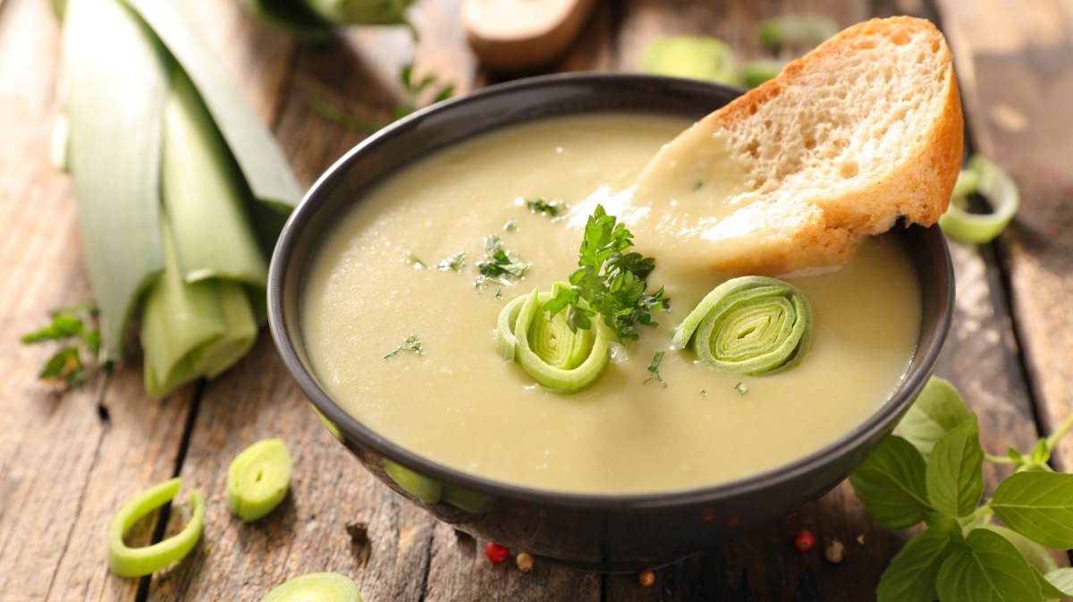 Cremige Suppe mit Kartoffeln und Lauch in einer schwarzen Suppenschale.