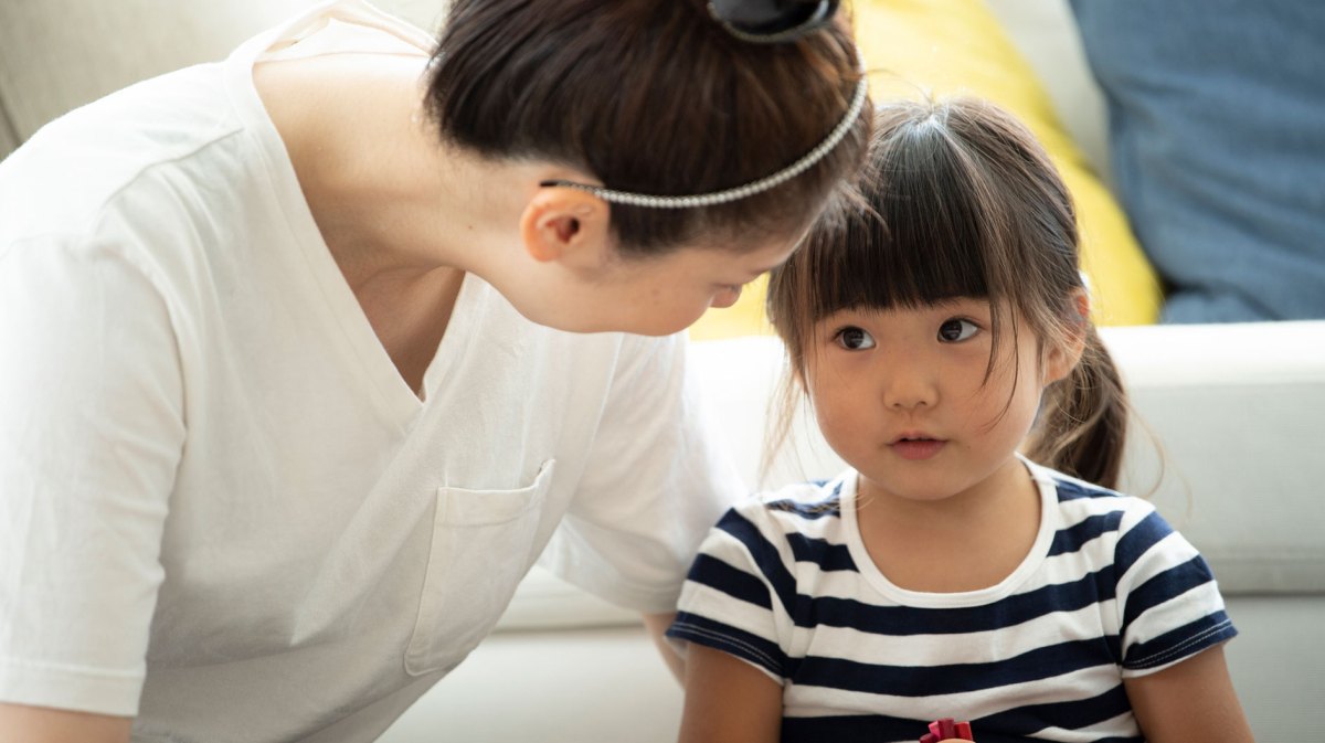 Mutter und Tochter schauen einander an, die Tochter wirkt dabei eingeschüchtert.