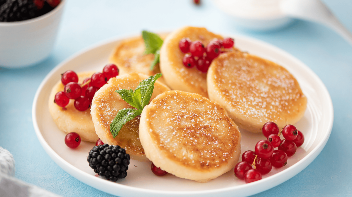 Kleine Pancakes auf einem weißen Teller.