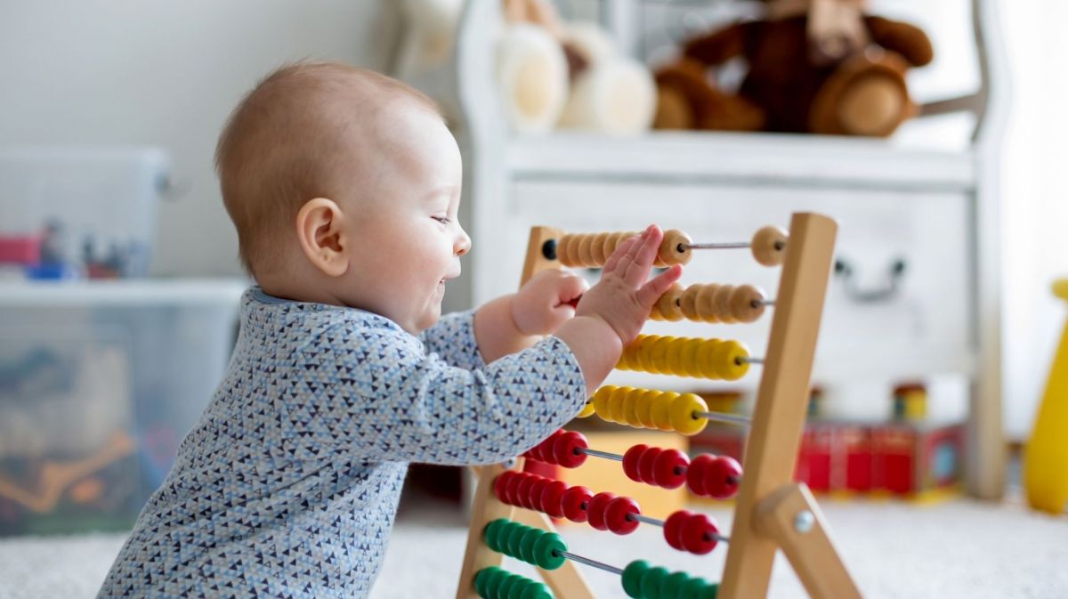 Niedlicher kleiner Junge, der zu Hause mit dem Abakus spielt