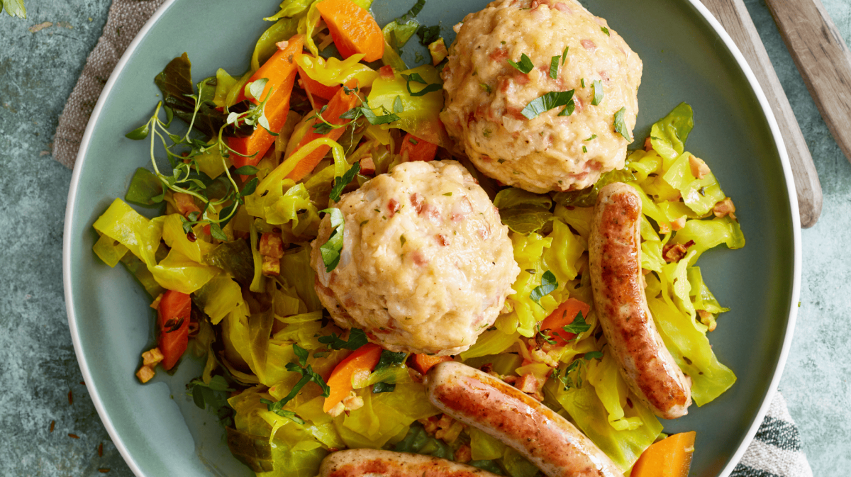 Speckknödel auf Weißkohl mit nürnberger Würstchen.