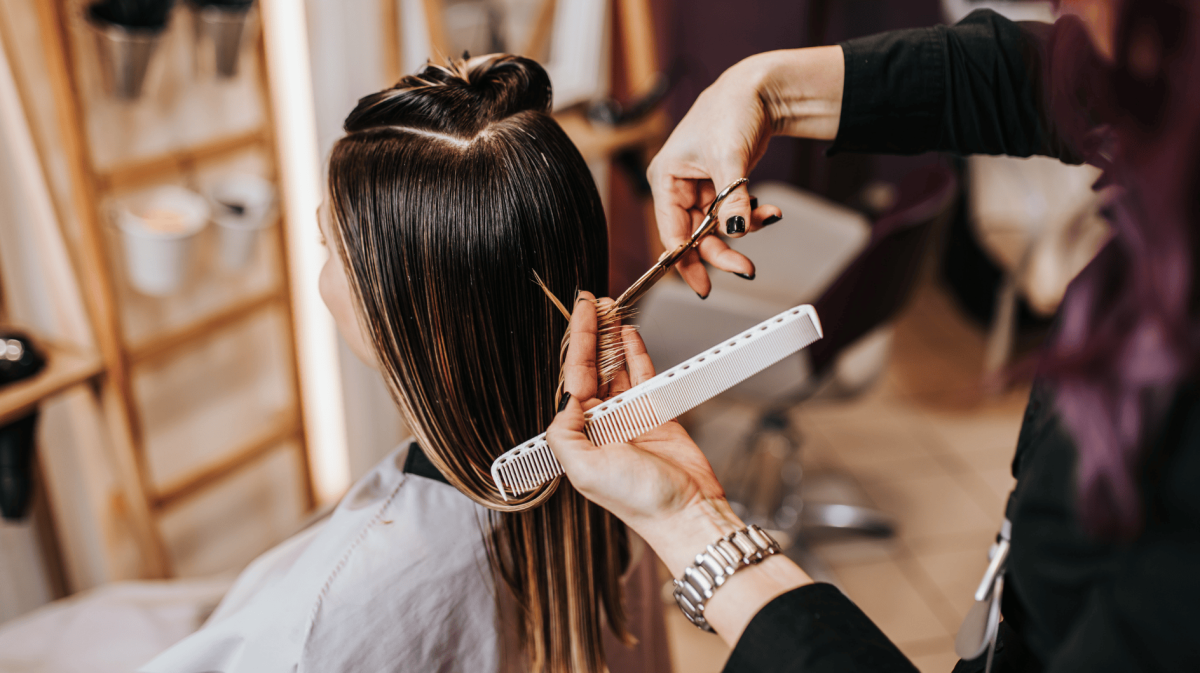 Frau sitzt beim Friseur.