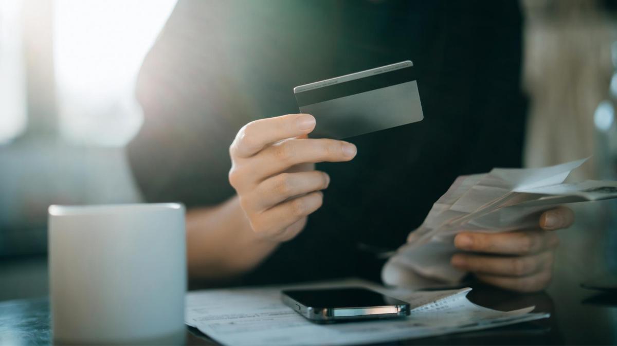 Frau hält eine Bankkarte in der Hand.